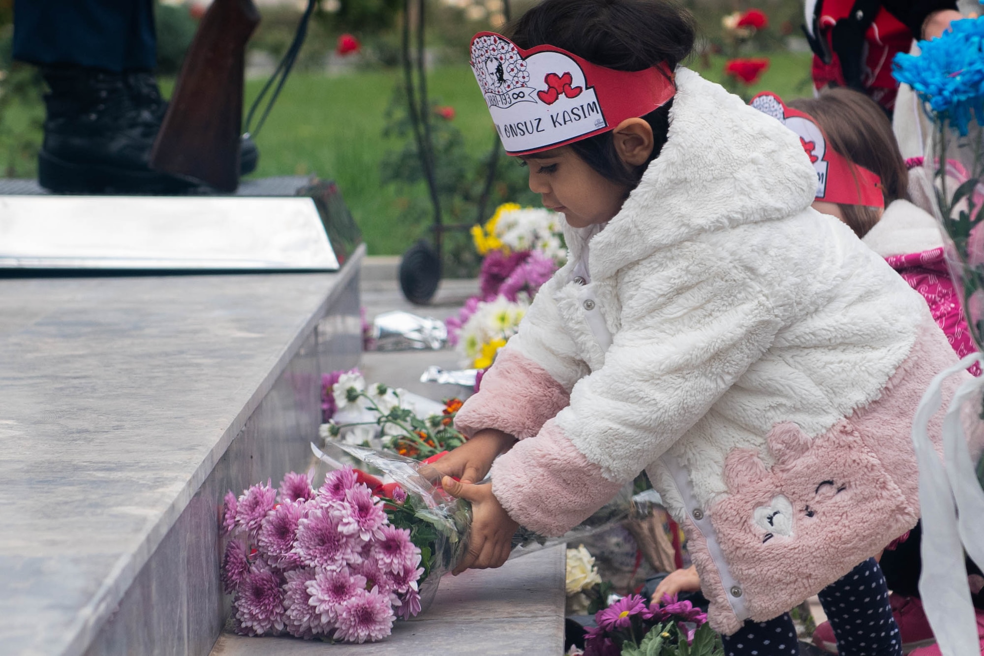 A child lays a bouquet of flowers on the Mustafa Kemal Atatürk statue during the Ataturk Memorial Day ceremony