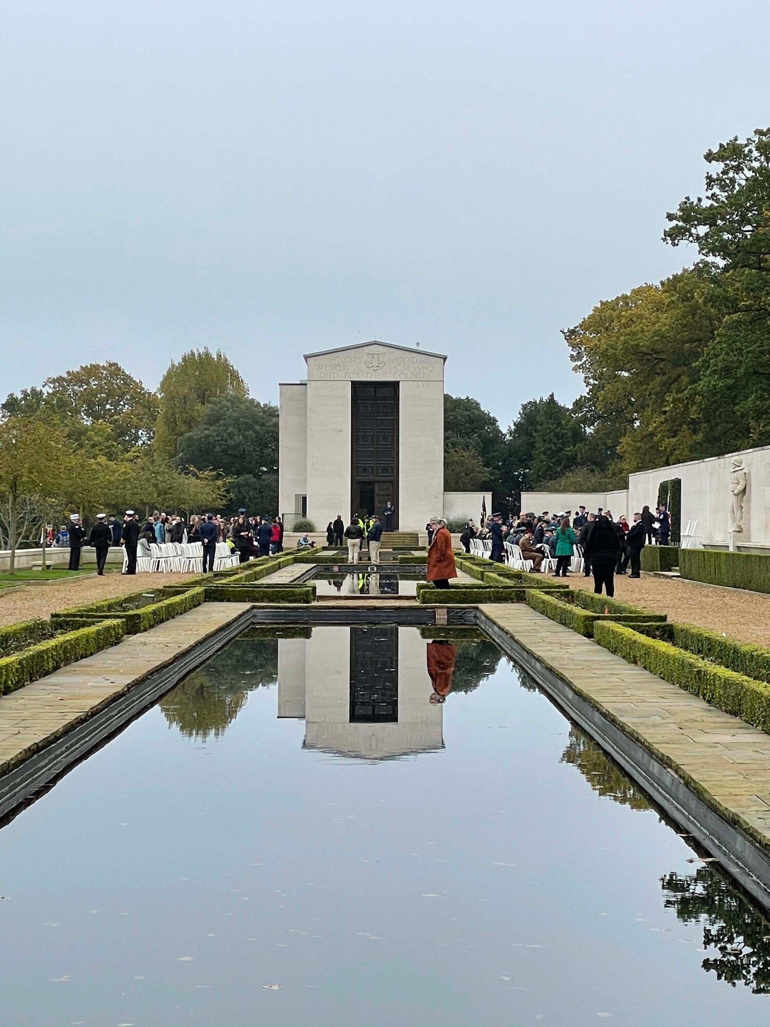 A group of U.S., Canada, and Royal Air Force servicemembers stand during a moment of silence to honor deceased military veterans, Cambridge, England, Nov. 11, 2021.Distinguished visitors and veterans were invited to participate in the ceremony by placing wreathes along the Tablets of the Missing. (U.S. Air Force photo by Senior Airman Joseph Barron).