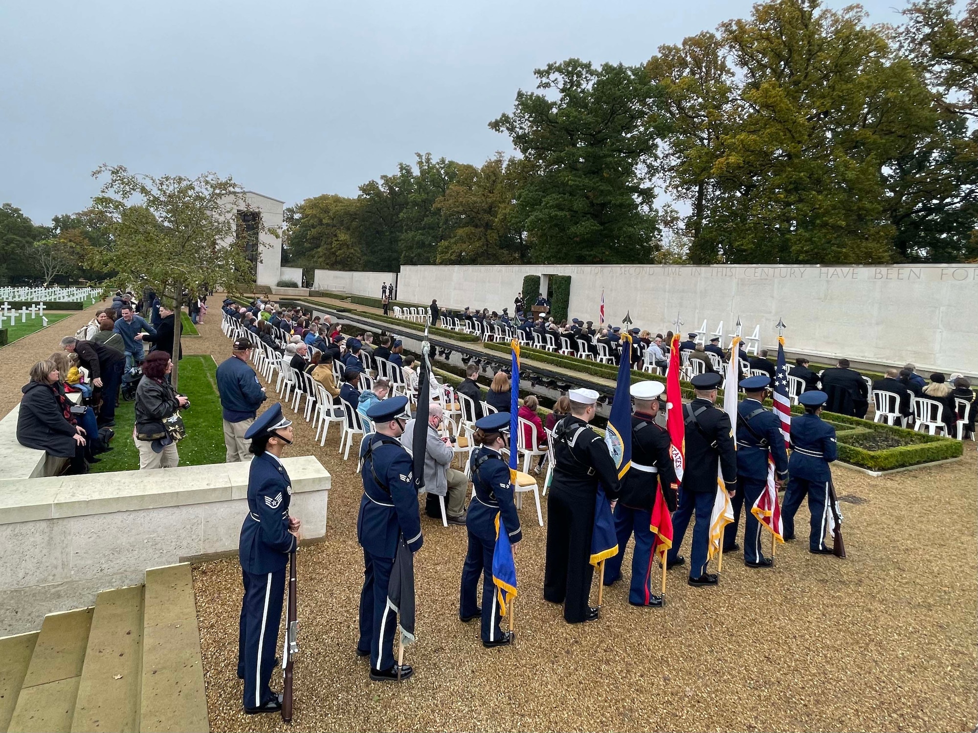 A group of U.S., Canada, and Royal Air Force servicemembers stand during a moment of silence to honor deceased military veterans, Cambridge, England, Nov. 11, 2021.Distinguished visitors and veterans were invited to participate in the ceremony by placing wreathes along the Tablets of the Missing. (U.S. Air Force photo by Senior Airman Joseph Barron).