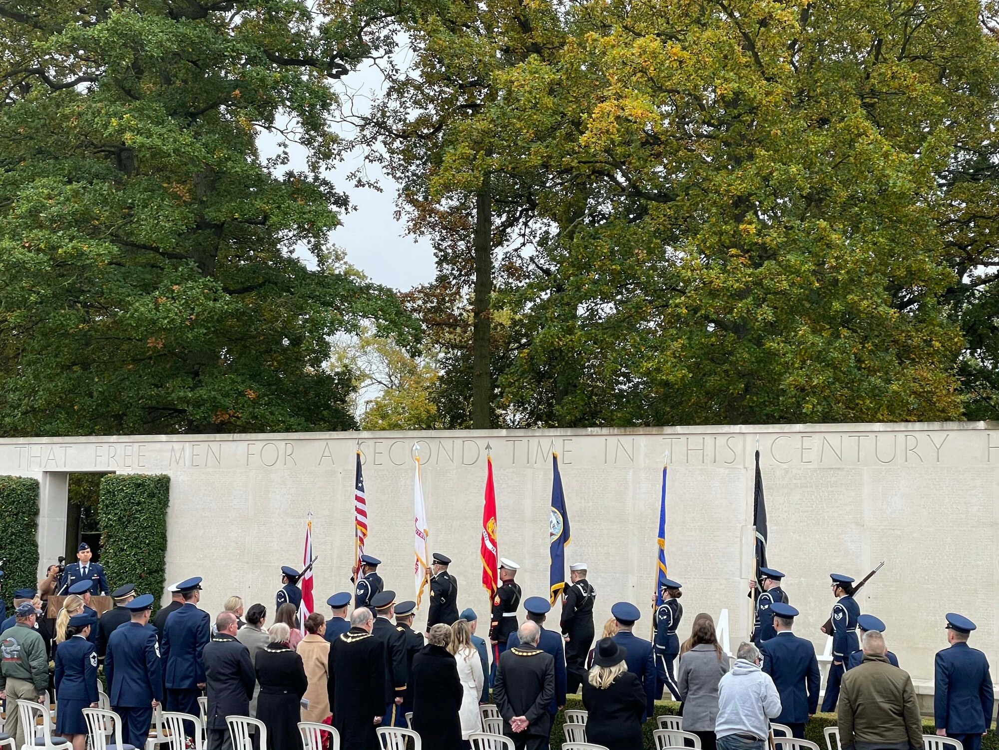 A group of U.S., Canada, and Royal Air Force servicemembers stand during a moment of silence to honor deceased military veterans, Cambridge, England, Nov. 11, 2021.Distinguished visitors and veterans were invited to participate in the ceremony by placing wreathes along the Tablets of the Missing. (U.S. Air Force photo by Senior Airman Joseph Barron).