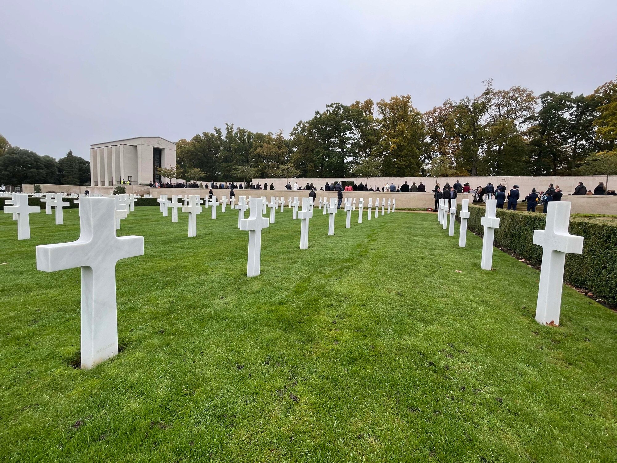 A group of U.S., Canada, and Royal Air Force servicemembers stand during a moment of silence to honor deceased military veterans, Cambridge, England, Nov. 11, 2021.Distinguished visitors and veterans were invited to participate in the ceremony by placing wreathes along the Tablets of the Missing. (U.S. Air Force photo by Senior Airman Joseph Barron).