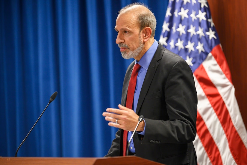 A man stands behind a lectern.