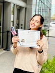 Pfc. Savana Neves, operating room specialist for Bayne-Jones Army Community Hospital, at the Joint Readiness Training and Fort Polk, Louisiana poses with her certificate of U.S. Citizenship outside the U.S. Citizenship and Immigration office in New Orleans Oct. 29