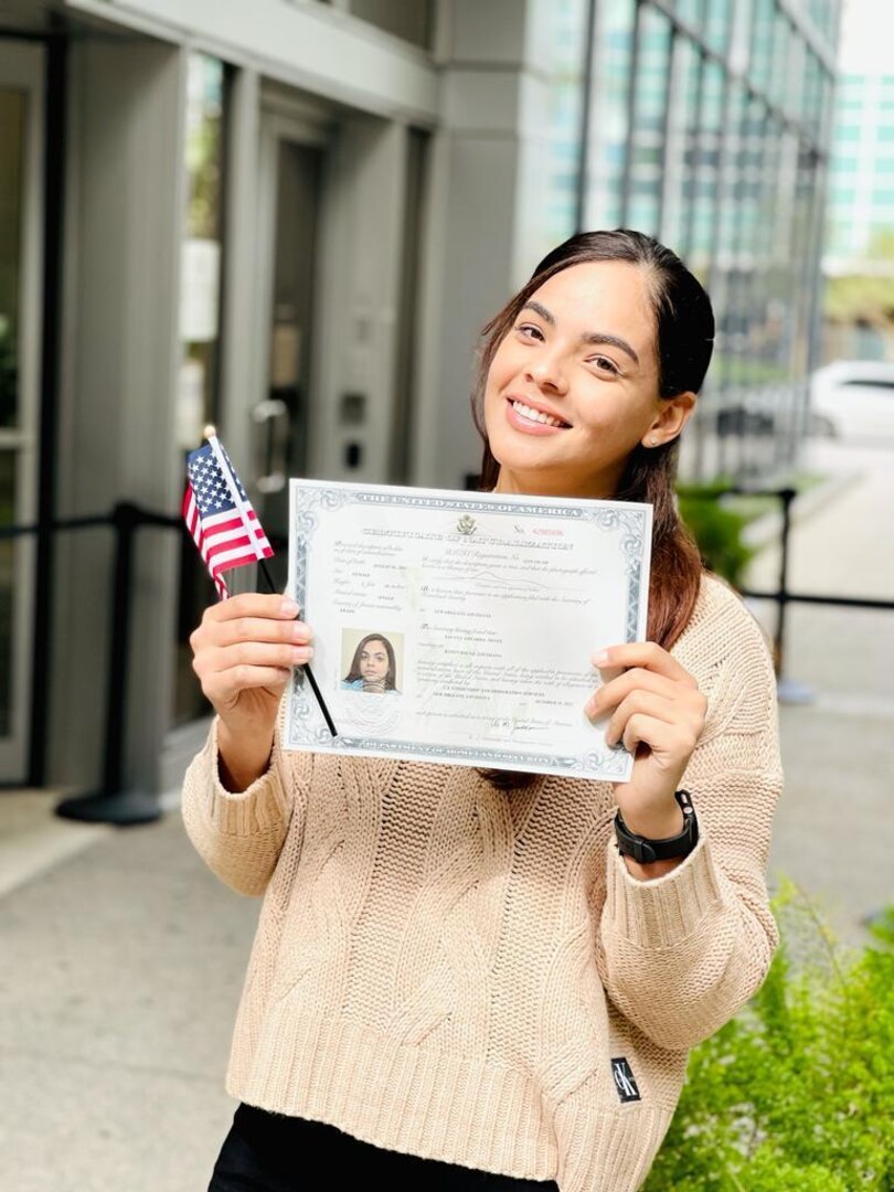 Pfc. Savana Neves, operating room specialist for Bayne-Jones Army Community Hospital, at the Joint Readiness Training and Fort Polk, Louisiana poses with her certificate of U.S. Citizenship outside the U.S. Citizenship and Immigration office in New Orleans Oct. 29