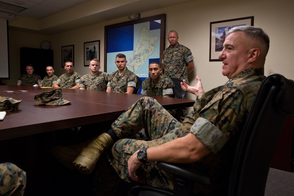 Men in uniform sitting at a meeting table indoors.