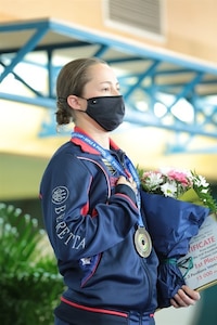 Female standing with medal and flowers