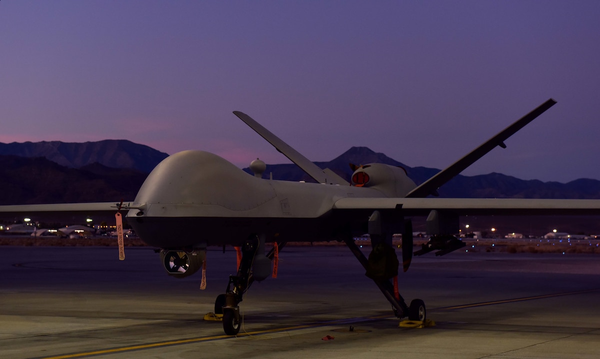 An MQ-9 Reaper sits under a sunshade in the early morning at Creech Air Force Base, Nevada, Oct. 25, 2019. Reapers and the Airmen that support the Remotely Piloted Aircraft mission are integral parts in fighting the war overseas. (U.S. Air Force photo by Senior Airman Haley Stevens)