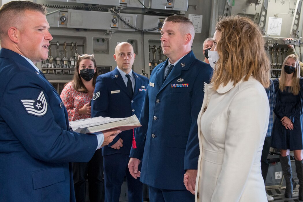 U.S. Air Force Tech. Sgt. Corey Chaney, left, an aircraft electrician for the 167th Maintenance Group, officiates the wedding of Tech. Sgt. Jonathen and Angela Guzik, on a C-17 Globemaster III aircraft at the 167th Airlift Wing, Oct. 19, 2021. Staff Sgt. Justin Watson, center, served as the best man for Tech. Sgt. Guzik, both Airmen serve as an aircraft metals technician for the 167th Maintenance Group. (U.S. Air National Guard photo by Senior Master Sgt. Emily Beightol-Deyerle)