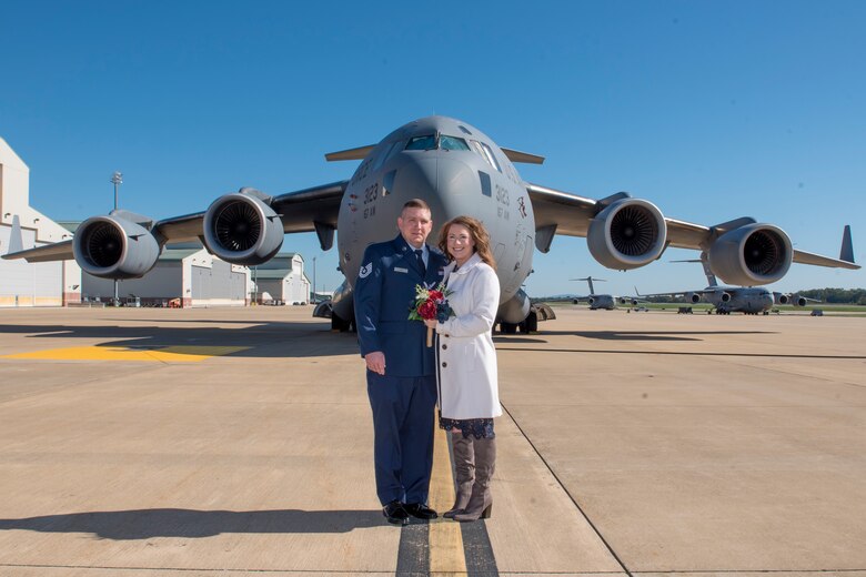 U.S. Air Force Tech. Sgt. Johnathen Guzik and his wife Angela pose in front of a C-17 Globemaster III aircraft after their wedding ceremony which took place inside the cargo area of the aircraft, Oct. 19, 2021. Tech. Sgt. Guzik is an aircraft metals technician for the 167th Maintenance Group. (U.S. Air National Guard photo by Senior Master Sgt. Emily Beightol-Deyerle)