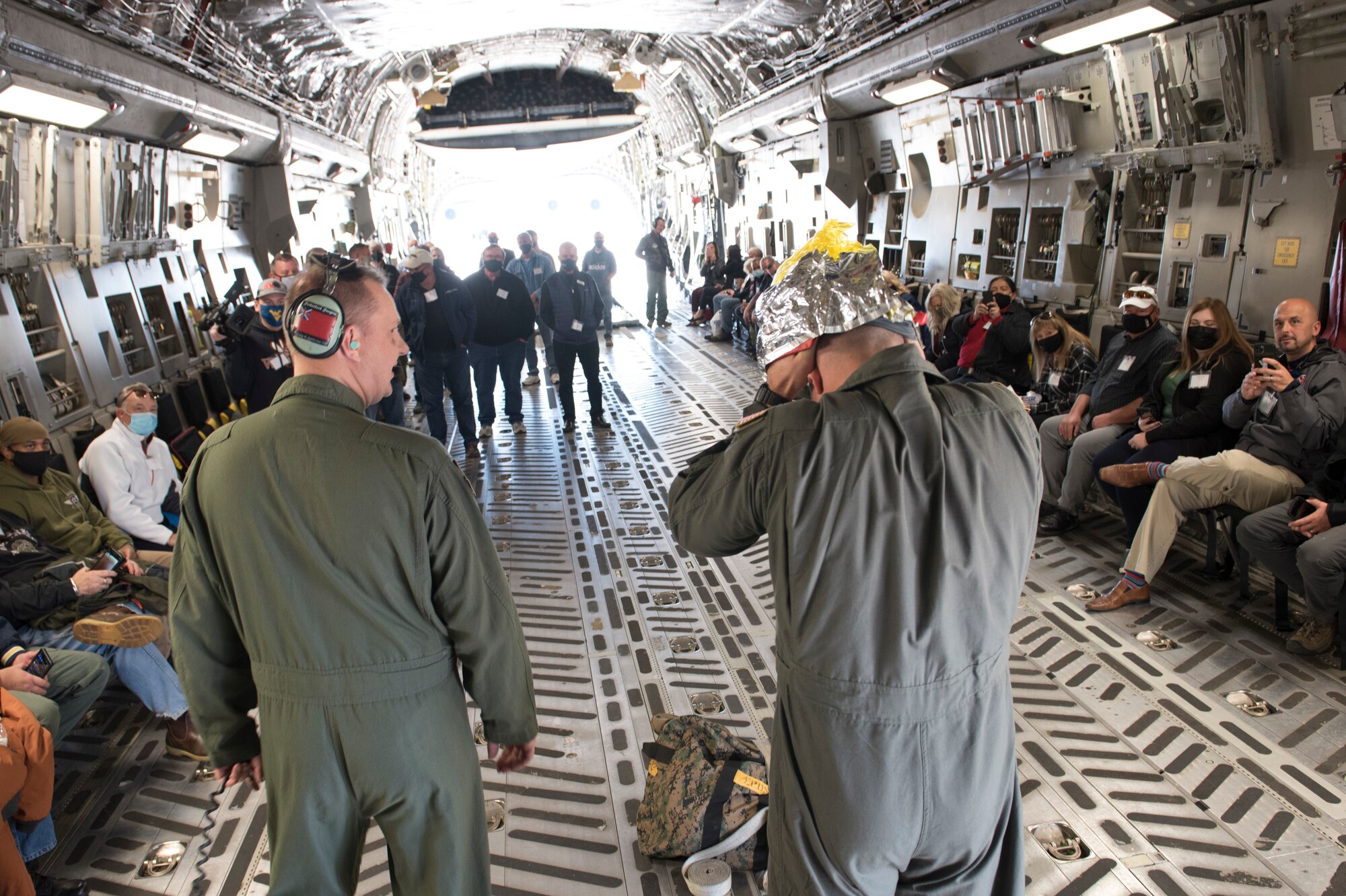 U.S. Air Force Senior Master Sgt. John Ratcliffe and Tech. Sgt. Mark Darlington, loadmaster for the 167th Operations Group, brief emergency procedures to passengers on a C-17 Globemaster III aircraft, Shepherd Field, Martinsburg, West Virginia, Nov. 9, 2021. Nearly 50 employers flew on the C-17 as part of the Employer Support of the Guard and Reserve Bosslift event at the unit.
