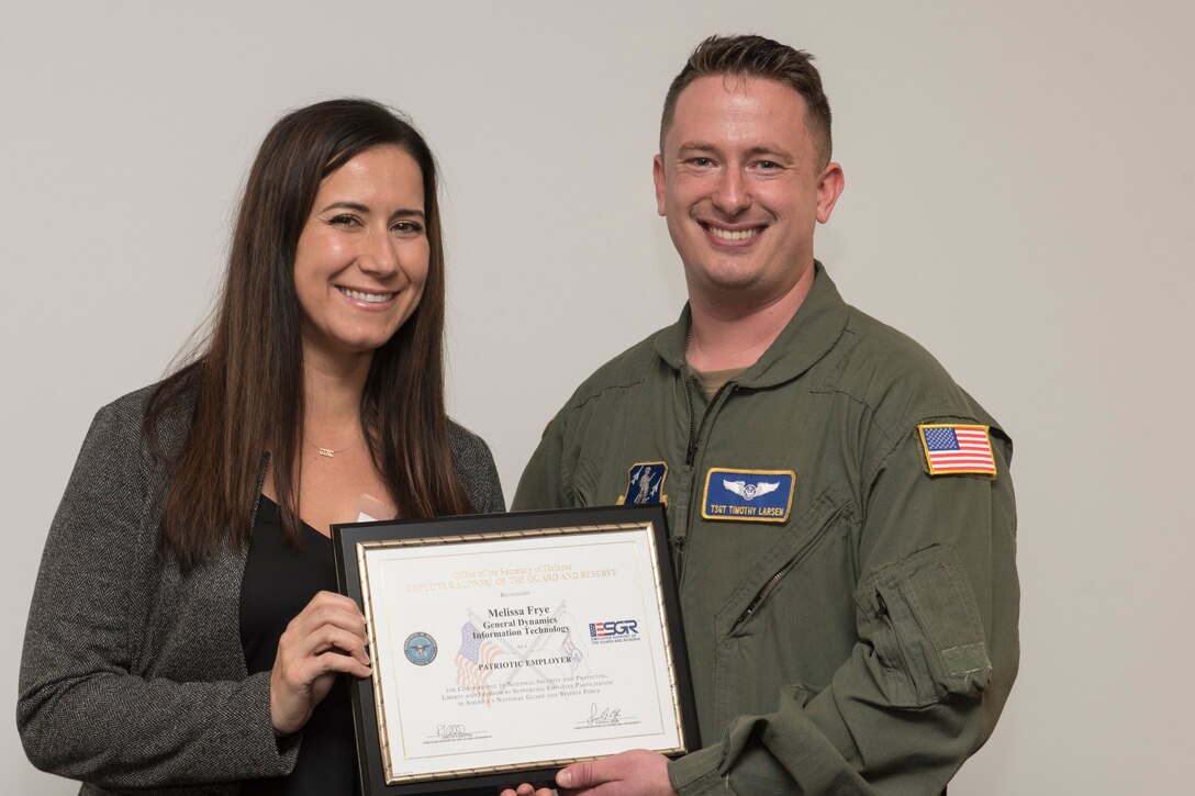 Tech. Sgt. Timothy Larsen, a loadmaster for the 167th Operations Group, presents Melissa Frye his boss at his civilian employment, with the Patriot Award during the Employer Support of the Guard and Reserve Bosslift event at the 167th Airlift Wing, Martinsburg, West Virginia, Nov. 9, 2021. The Patriot Award recognizes the support given to Guard and Reserve members by their civilian employer. (U.S. Air National Guard photo by Senior Master Sgt. Emily Beightol-Deyerle)