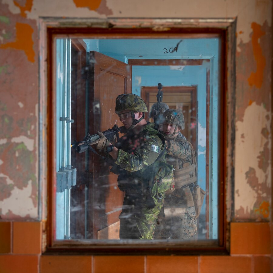 Corps of Royal Canadian Engineers Spr. Michael Lucyshyn, a combat engineer with 2 Combat Engineer Regiment, 2 Canadian Mechanized Brigade Group, 4th Canadian Division, and U.S. Marine Corps Lance Cpl. Owen McGee, a combat engineer with Mobility Assault Company, 2d Combat Engineer Battalion, 2d Marine Division, rehearse clearing and securing a building during Exercise Bold Quest 21.2 at Muscatatuck Urban Training Center, Ind., Nov. 6, 2021.
