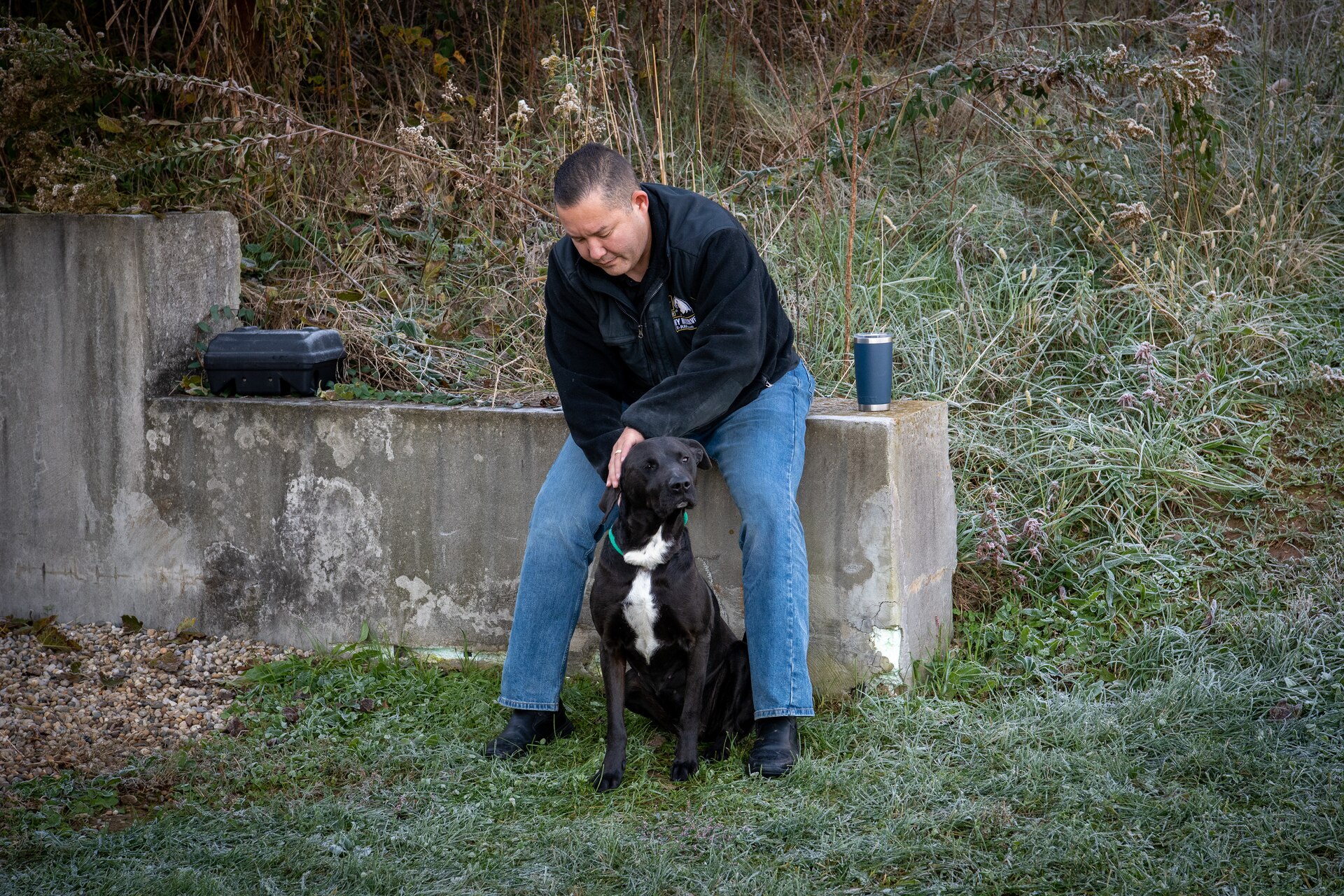 a man pets a dog.