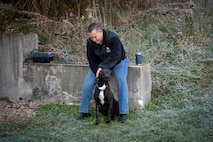 a man pets a dog.