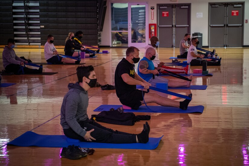 people on yoga mats using tension bands to stretch.