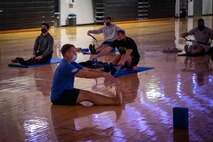 people on yoga mats reaching for their toes.