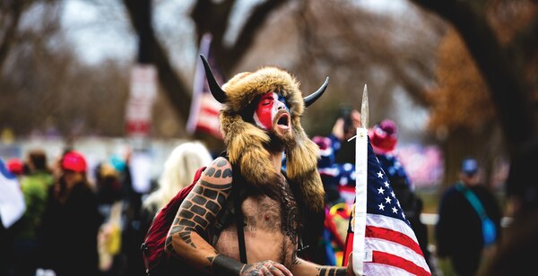 Insurrection at the U.S. Capitol: QAnon Shaman, Jake Angeli” (Johnny Silvercloud At Shutterstock)