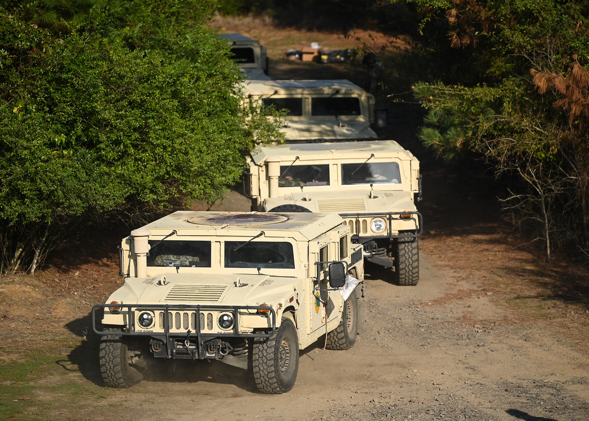 A convoy of military vehicles enters an urban terrain village
