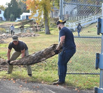 IMAGE: Members of the Potomac River Test Range (PRTR) maintenance crew carry a large piece of driftwood off the beach surrounding a PRTR range station in Colonial Beach, Nov. 10.