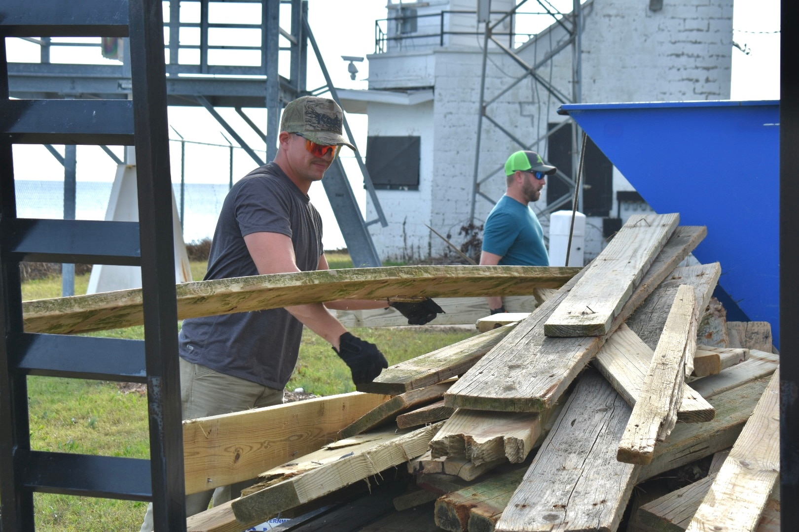 IMAGE: A member of the Potomac River Test Range (PRTR) maintenance crew stacks rouge planks onto a trailer during clean up around a Colonial Beach-based range station belonging to the PRTR. The planks were blown off and carried away during a windy tidal surge that occurred recently.