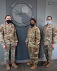 Photo of 919 SOCS Leadership standing next to their squadron emblem