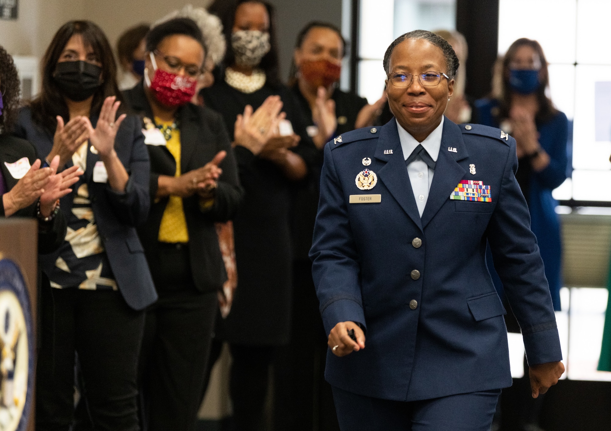 Col. Gwendolyn Foster, 60th Medical Group commander, walks down to receive California’s 3rd Congressional District’s “Women of the Year” award Nov. 9, 2021, at Woodland Community College. Also receiving the award was Col. Erin Cook, 349th Maintenance Group commander.  Both women are senior leaders stationed at Travis Air Force Base, California. (U.S. Air Force Photo by Grant Okubo)