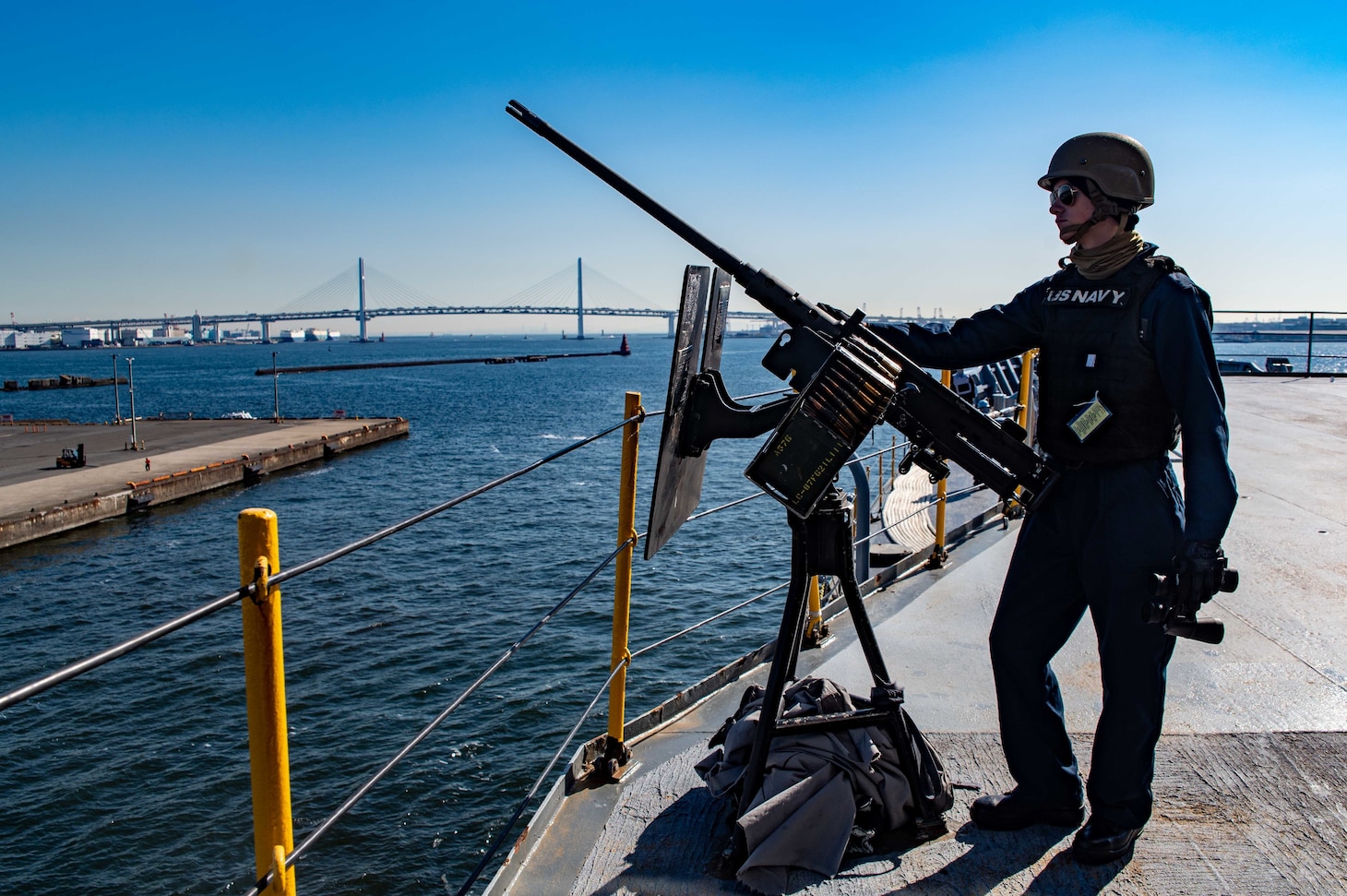YOKOHAMA, Japan (Nov. 15, 2021) – Gunner’s Mate Seaman Nathanial Winters, from Peru, Ind., assigned to the Emory S. Land-class submarine tender USS Frank Cable (AS 40), mans an M2A1 .50 caliber machine gun as the ship prepares to moor in Yokohama, Japan, Nov. 15. Frank Cable is on patrol conducting expeditionary maintenance and logistics in support of national security in the U.S. 7th Fleet area of operations. (U.S. Navy photo by Mass Communication Specialist 1st Class Charlotte C. Oliver)