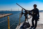 YOKOHAMA, Japan (Nov. 15, 2021) – Gunner’s Mate Seaman Nathanial Winters, from Peru, Ind., assigned to the Emory S. Land-class submarine tender USS Frank Cable (AS 40), mans an M2A1 .50 caliber machine gun as the ship prepares to moor in Yokohama, Japan, Nov. 15. Frank Cable is on patrol conducting expeditionary maintenance and logistics in support of national security in the U.S. 7th Fleet area of operations. (U.S. Navy photo by Mass Communication Specialist 1st Class Charlotte C. Oliver)