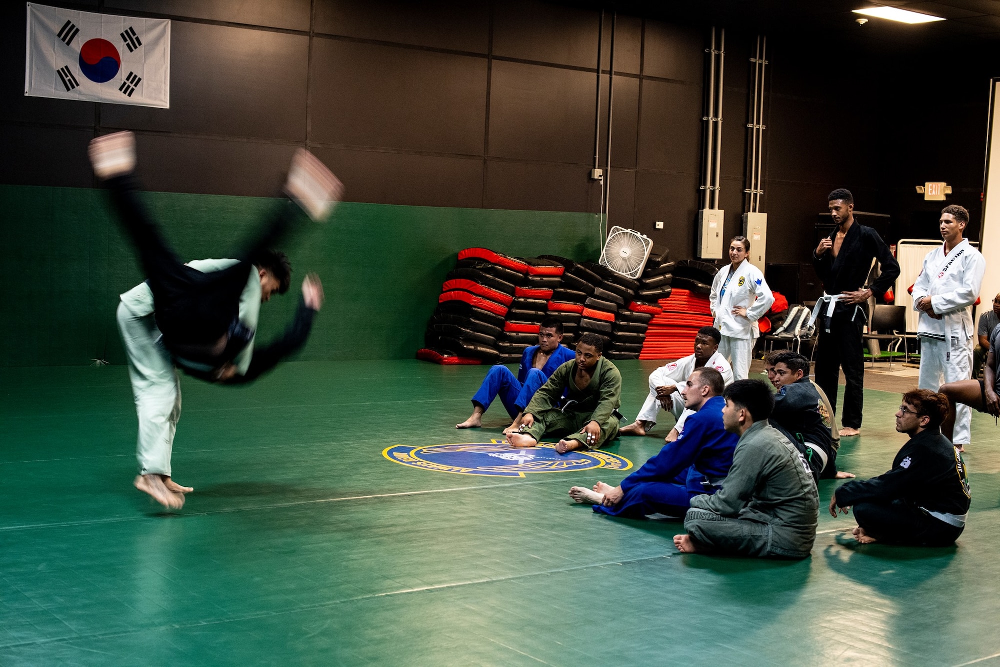 Master Sergeant Christopher Costa, 607th Air Support Operations Group section chief, performs a hip throw during a Brazilian Jui Jitsu class at Osan Air Base, Republic of Korea. The class is designed to develop and equip participants of all ranks and backgrounds with the necessary tools to develop physically and mentally.