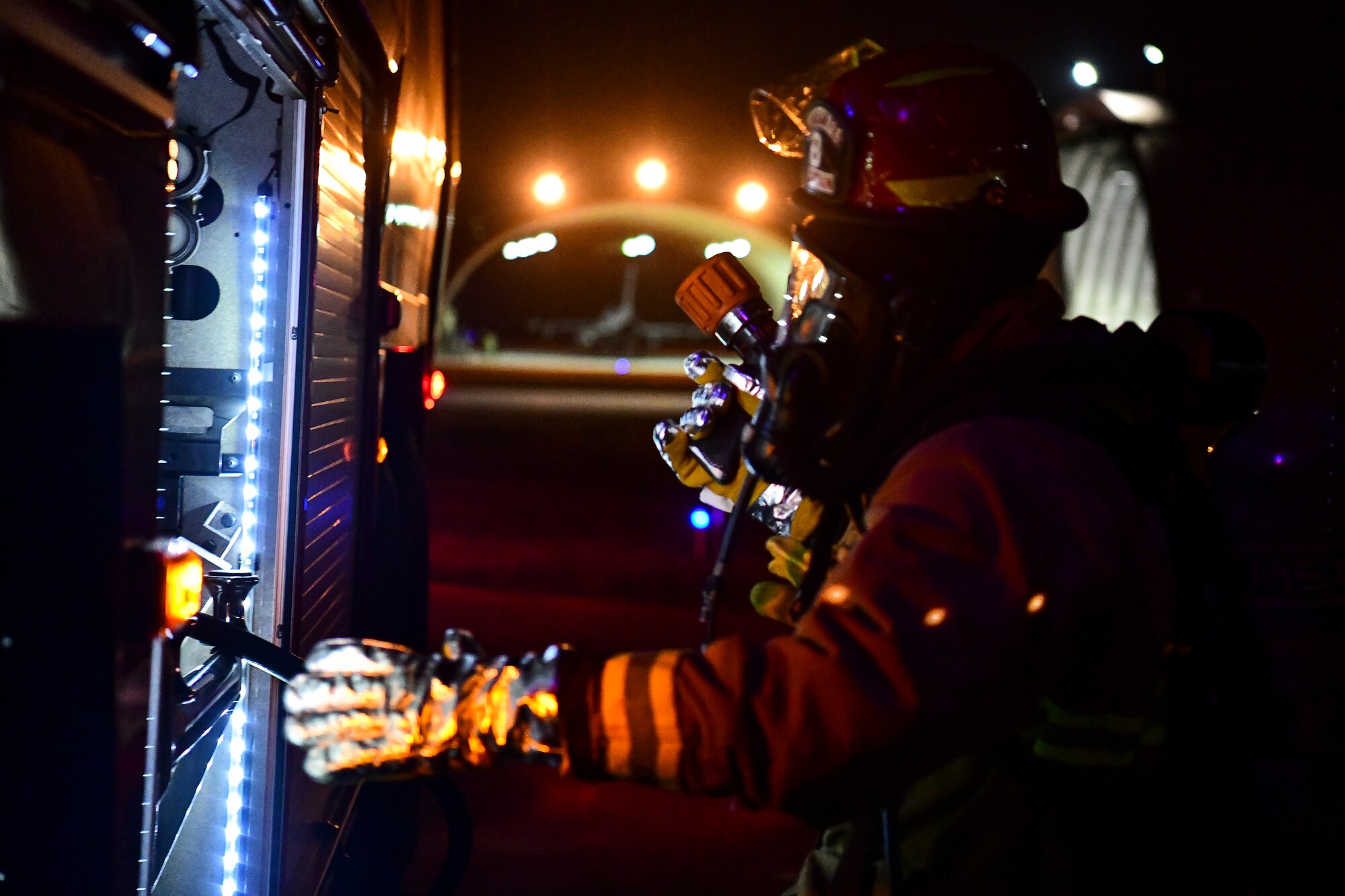 A firefighter turns a gauge.