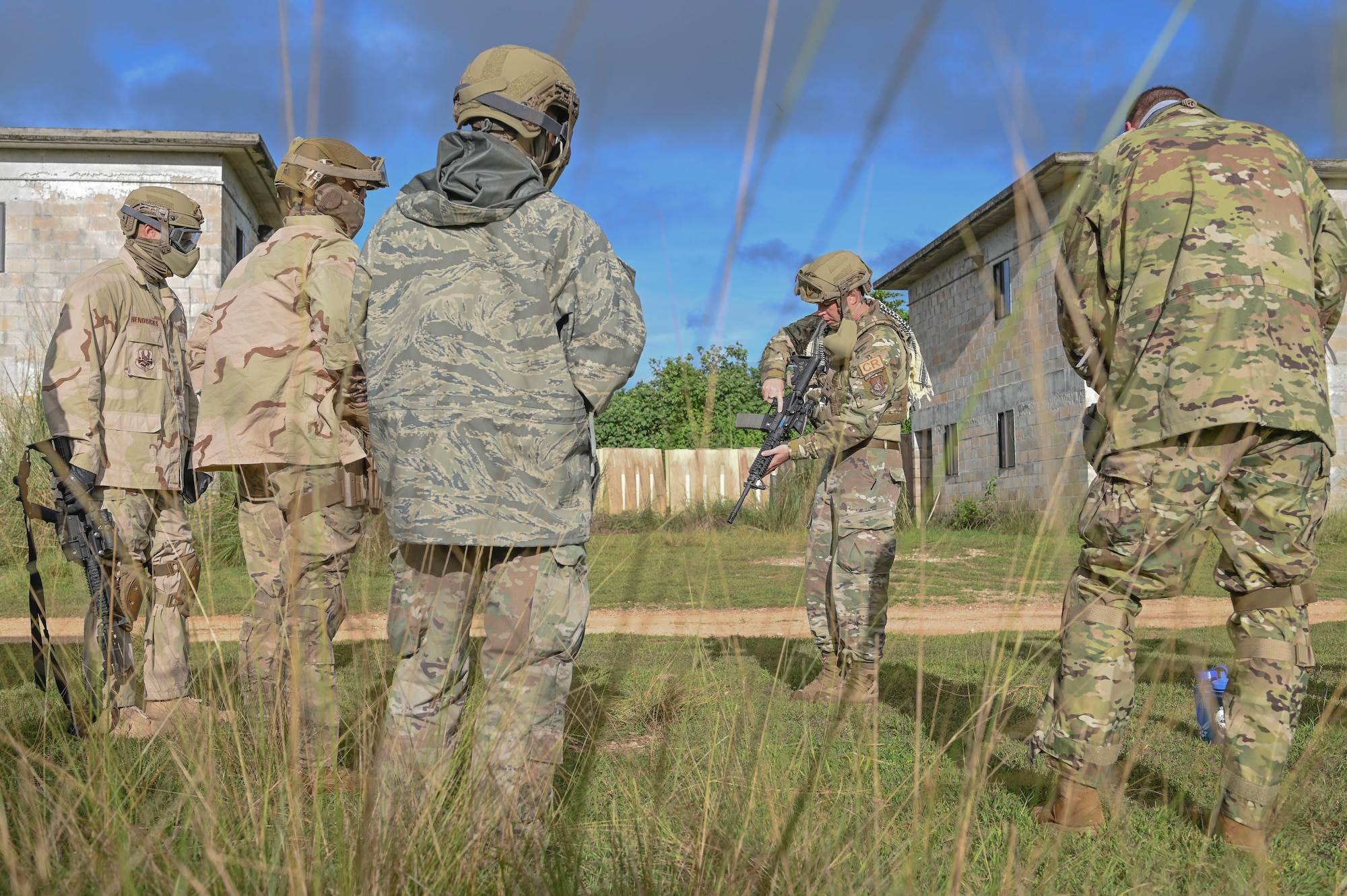 Airmen watching as another Airman points out features on a weapon.