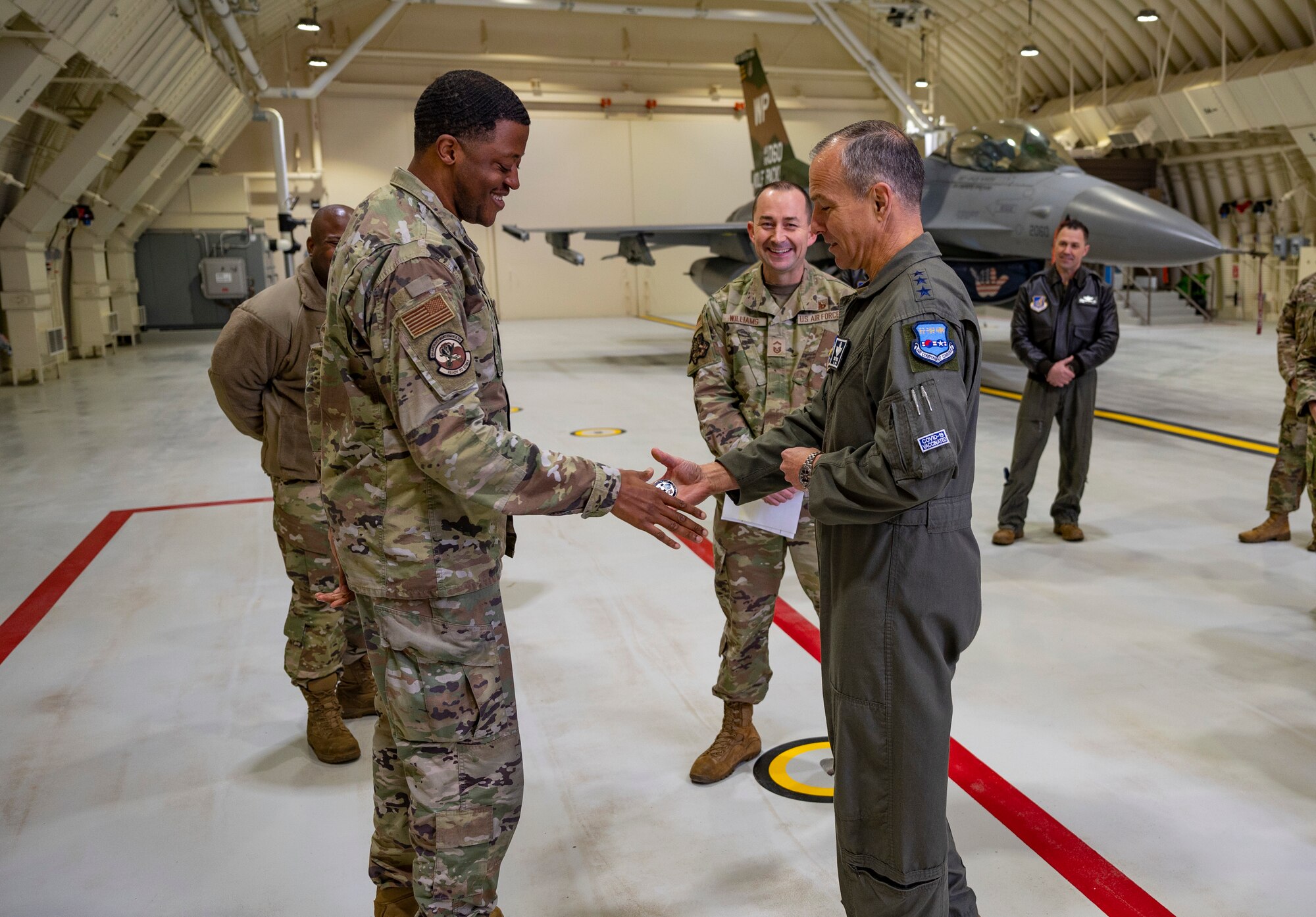 Lt. Gen. Scott Pleus, Seventh Air Force commander, coins Staff Sgt. Ruben Wise Jr., 8th Aircraft Maintenance Squadron, while touring the Wolf Pack’s third generation hardened aircraft shelters at Kunsan Air Base, Republic of Korea, Nov. 10, 2021.
