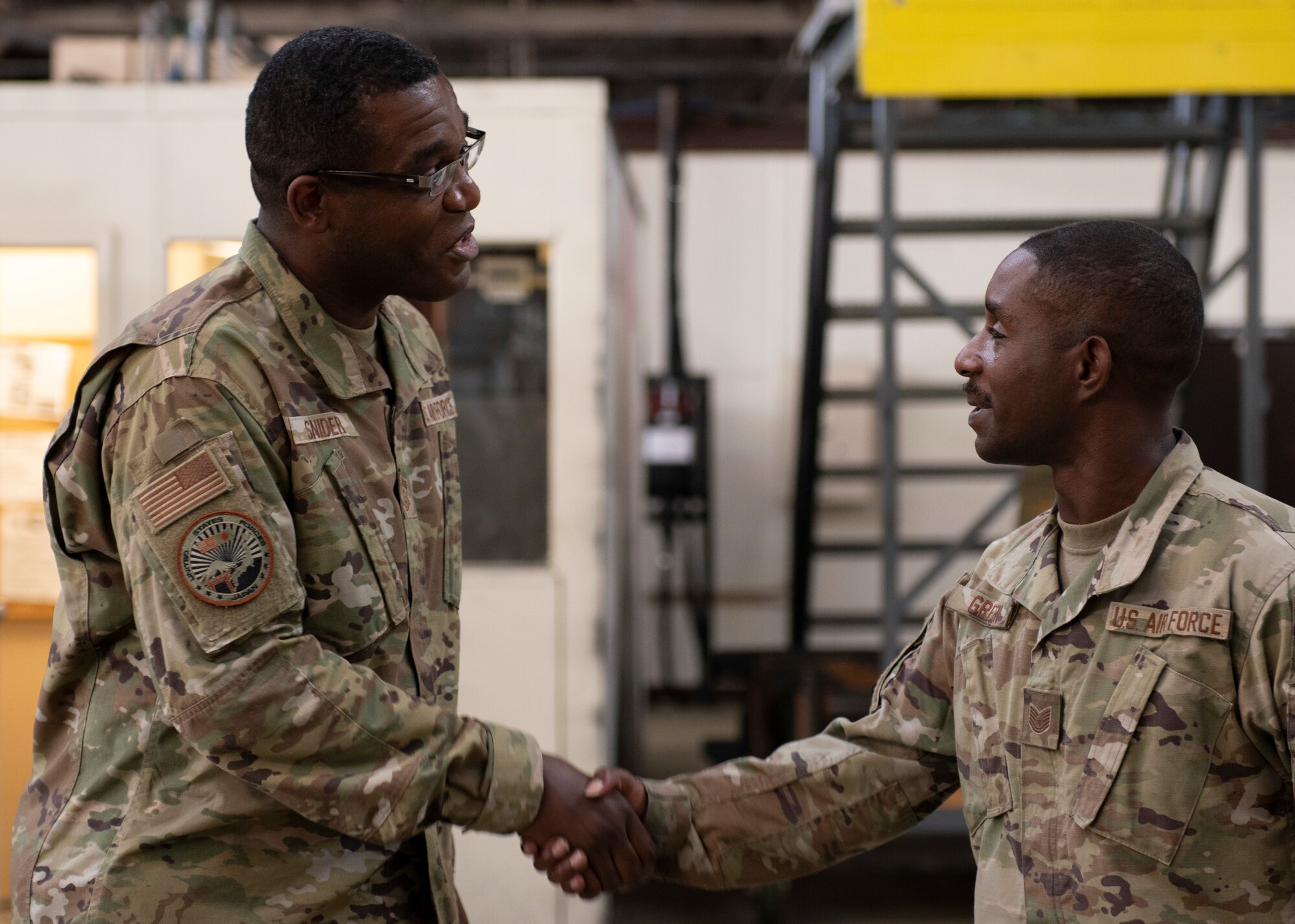 A USAF Chief shakes the hand of a Technical Sgt.