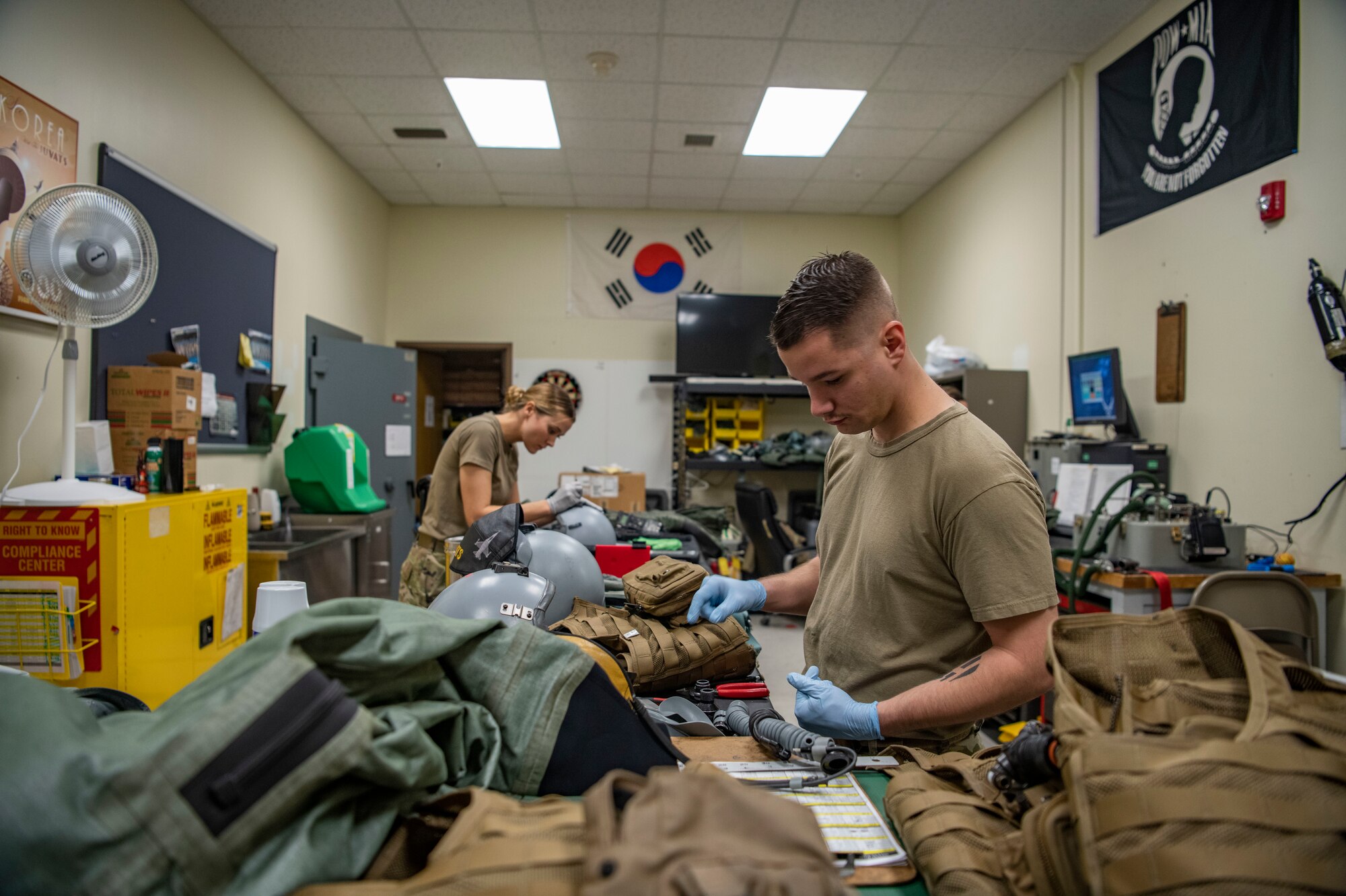 Senior Airman Cameron Nixon, right, 80th Fighter Squadron aircrew flight equipment technician, and Senior Airman Samantha Anderson, left, 80th FS AFE technician, disassemble flight helmets at Kunsan Air Base, Republic of Korea, Nov. 8, 2021. There are AFE Airmen at each Kunsan Air Base flying squadron to provide support to that specific squadron’s mission with instructions on how to inspect and maintain gear. (U.S. Air Force photo Staff Sgt. Jesenia Landaverde)