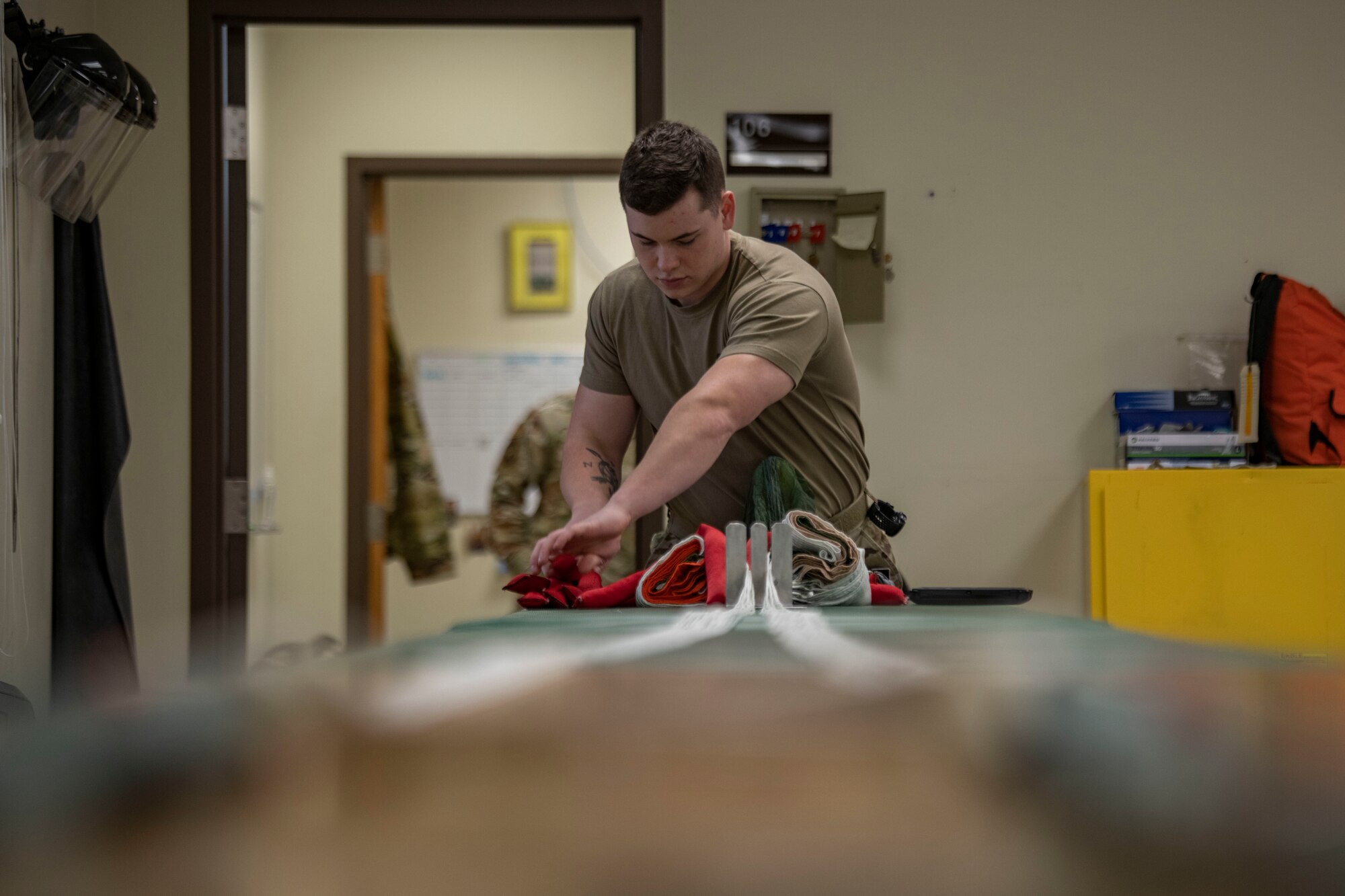 Senior Airman Colton Knight, 8th Operation Support Squadron aircrew flight equipment technician, pulls a parachute at Kunsan Air Base, Republic of Korea, Nov. 8, 2021. From packing emergency items like parachutes and survival kits to maintaining regularly used items like oxygen masks, the attention to detail by these Airmen could mean the difference between life and death. (U.S. Air Force photo Staff Sgt. Jesenia Landaverde)