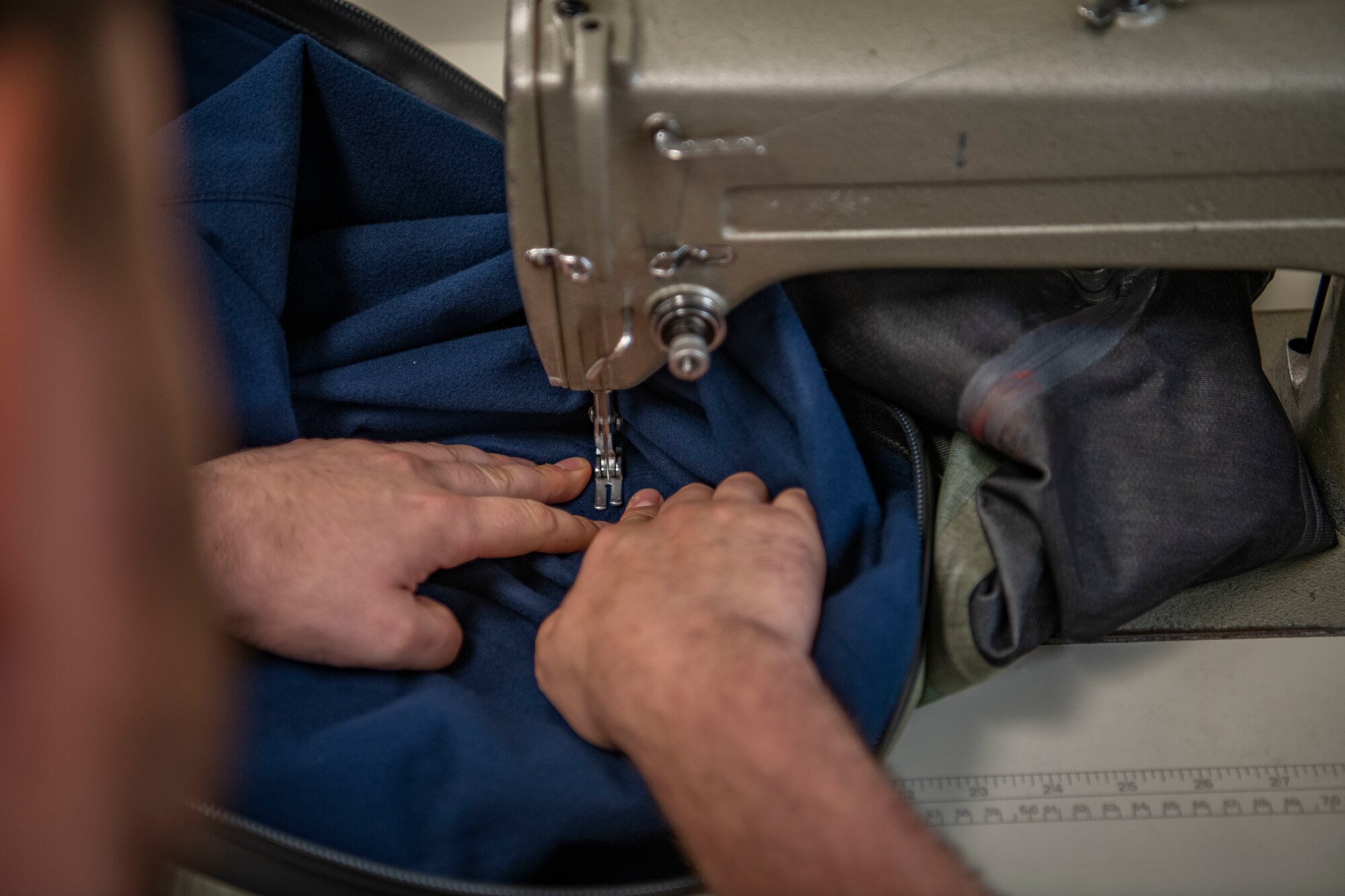 Senior Airman Martin Coetzee, 8th Operation Support Squadron aircrew flight equipment technician, sews an anti-exposure flight dry suit at Kunsan Air Base, Republic of Korea, Nov. 8, 2021. From packing emergency items like parachutes and survival kits to maintaining regularly used items like oxygen masks, the attention to detail by these Airmen could mean the difference between life and death. (U.S. Air Force photo Staff Sgt. Jesenia Landaverde)