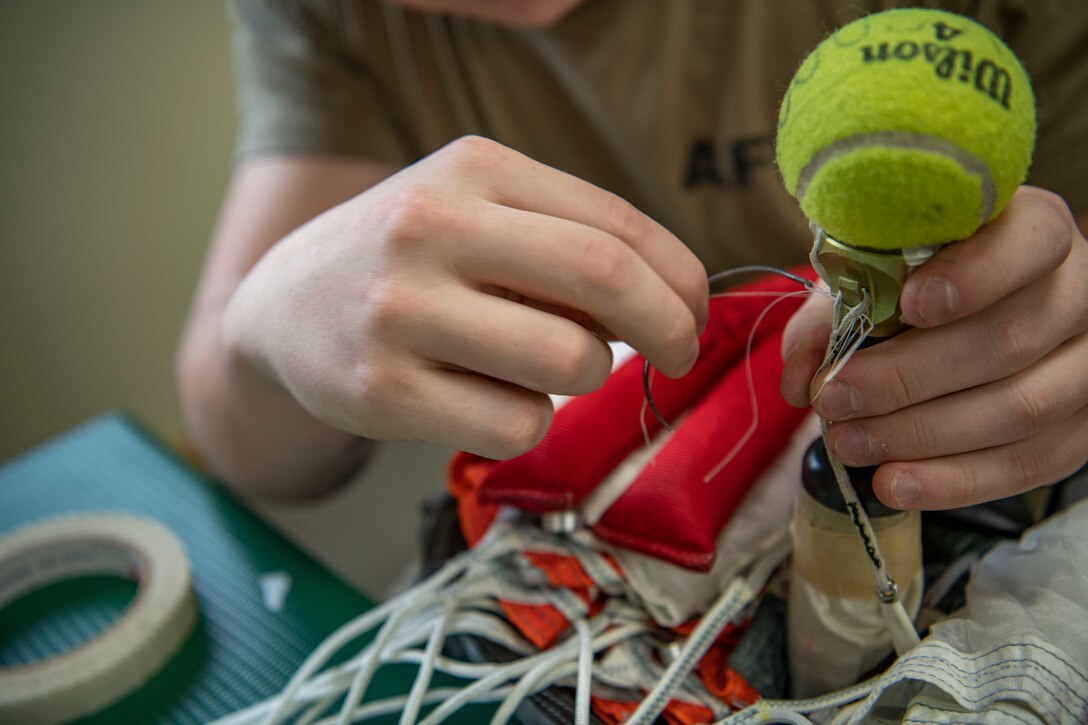 Senior Airman Colton Knight, 8th Operation Support Squadron aircrew flight equipment technician, stitches parachute cords together at Kunsan Air Base, Republic of Korea, Nov. 8, 2021. Aircrew Flight Equipment specialists make sure flyers have the supplies necessary for ensuring that all flight and safety equipment is in the perfect working order. (U.S. Air Force photo Staff Sgt. Jesenia Landaverde)