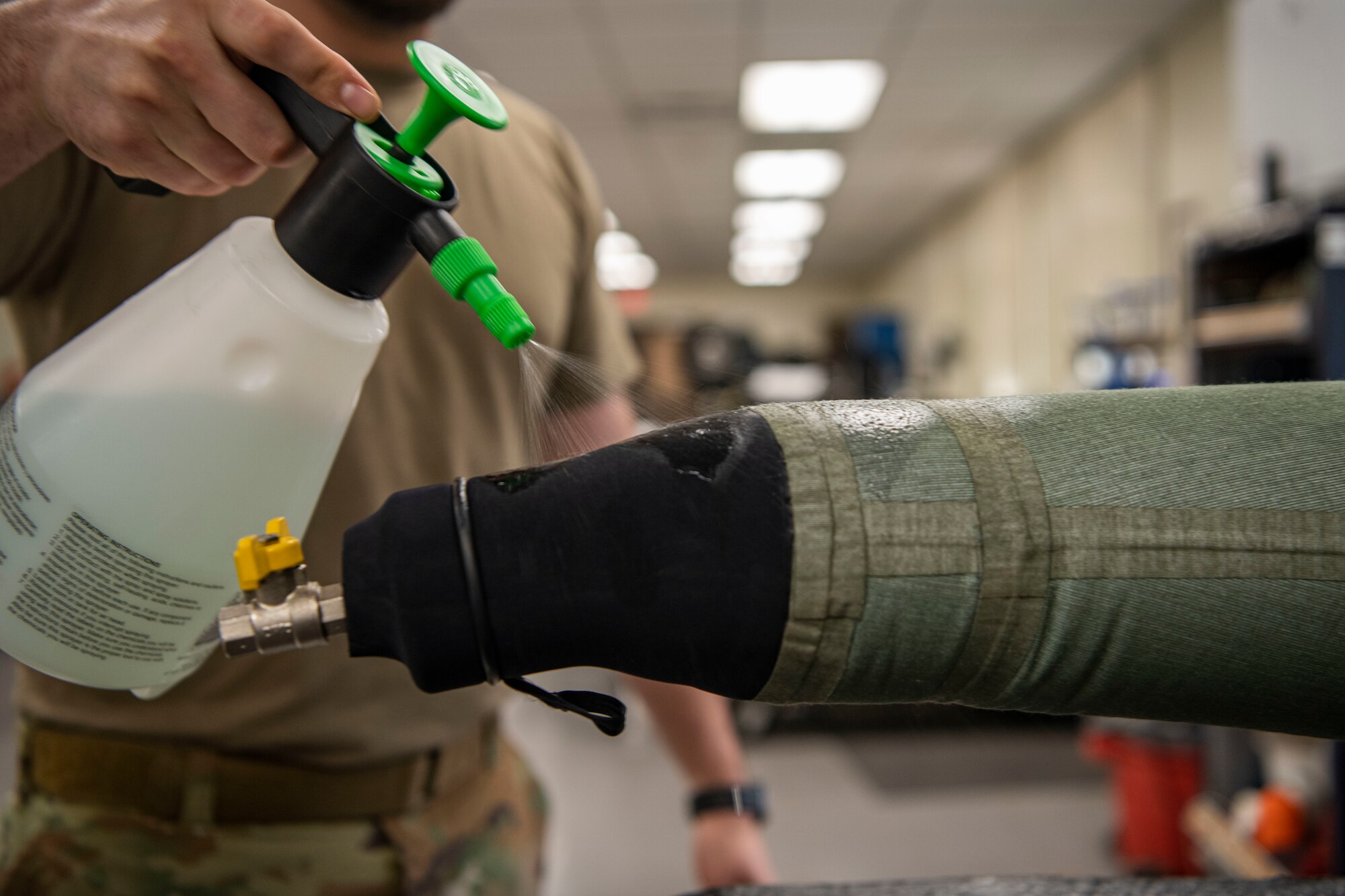 Senior Airman Martin Coetzee, 8th Operation Support Squadron aircrew flight equipment technician, sprays soap solution on an anti-exposure flight dry suit to test for leaks at Kunsan Air Base, Republic of Korea, Nov. 8, 2021. From packing emergency items like parachutes and survival kits to maintaining regularly used items like oxygen masks, the attention to detail by these Airmen could mean the difference between life and death. (U.S. Air Force photo Staff Sgt. Jesenia Landaverde)