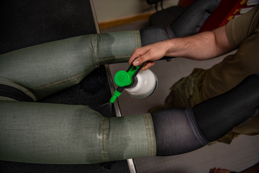 Senior Airman Martin Coetzee, 8th Operation Support Squadron aircrew flight equipment technician, sprays soap solution on an anti-exposure flight dry suit to test for leaks at Kunsan Air Base, Republic of Korea, Nov. 8, 2021. From packing emergency items like parachutes and survival kits to maintaining regularly used items like oxygen masks, the attention to detail by these Airmen could mean the difference between life and death. (U.S. Air Force photo Staff Sgt. Jesenia Landaverde)