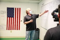 USS Toledo (SSN 769) Deputy Project Superintendent Eric Temple shares one of the boards used in the Operations Control Center (OCC) to track the ongoing tasks of the team; The OCC is one of the initiatives for Naval Sustainment Systems-Shipyard (NSS-SY) to support the workforce, contractors, and Sailors working around the clock to deliver the submarine back to the Fleet. The team is located in close proximity to the vessel and is available to assist the project in removing barriers and driving non-stop execution of work. Capt. Dianna Wolfson recently visited the team during an episode of America's Shipyard.