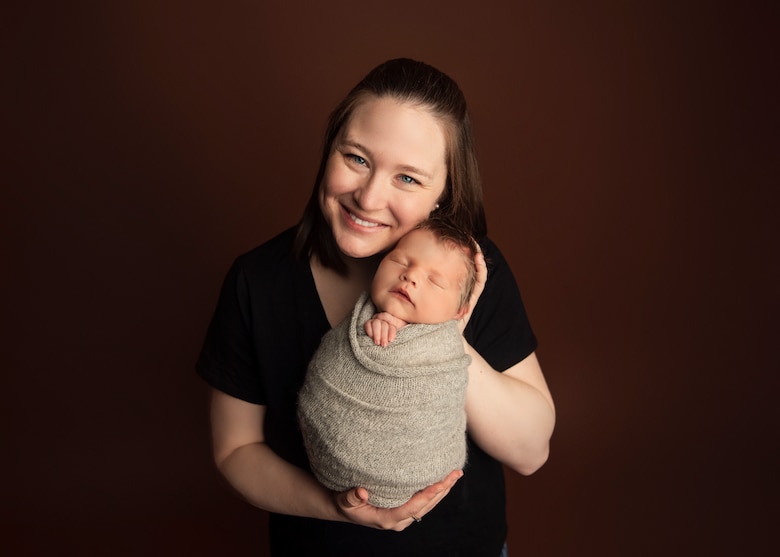 U.S. Air Force Maj. Jenna Waites poses with her child. While under official travel orders during her reassignment to the Command and General Staff College at Fort Leavenworth, Kansas, Waites was separated from her infant for a total of 10 days, reporting the cost of transporting a 14-day supply, 350 oz. or 45-lb shipment, of breast milk coming in at just under $500.