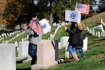 Chief Petty Officer Brian Sorensen and his children, Alexis and Blake, participate in the 12th annual Coast Guard Flags Across America event at Arlington National Cemetery Nov. 6, 2010. Members of FAA place flags at the graves of fallen Coast Guardsmen as part of the event. U.S. Coast Guard photo by Petty Officer 2nd Class Patrick Kelley.