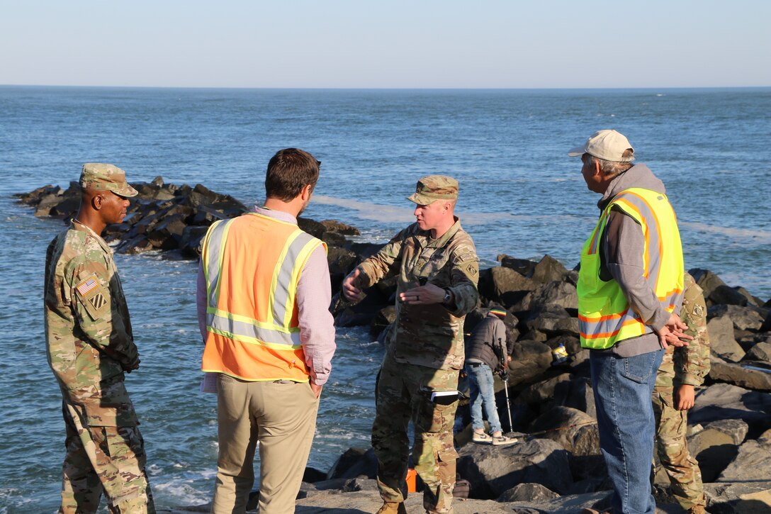 USACE Philadelphia District Deputy Commander MAJ Brandon Drobenak (middle), Christian Bickings (middle left), and Carl Cipriani (right) brief Command Sergeant Major (CSM) Patrickson Toussaint (left) on the Absecon Inlet seawall in Atlantic City during a November 2021 visit.