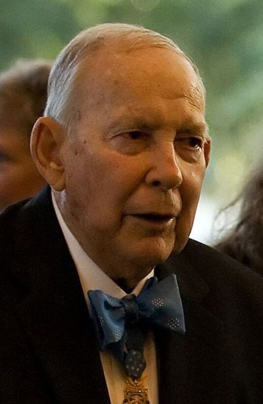 An older man wears a suit and bow tie.