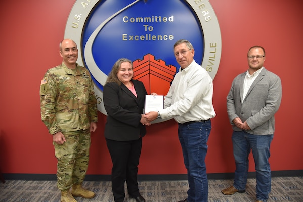 David Nieman, Missile Defense Agency Mission Support Facilities director, present Huntsville Center’s Tara Clark, Branch Chief, Missile Defense Mandatory Center of Expertise, with a letter of appreciation Nov. 4 as Col. Sebastien Joly, Huntsville Center commander, and Rickie Stanford, MDAMSF facility engineer, stand by.