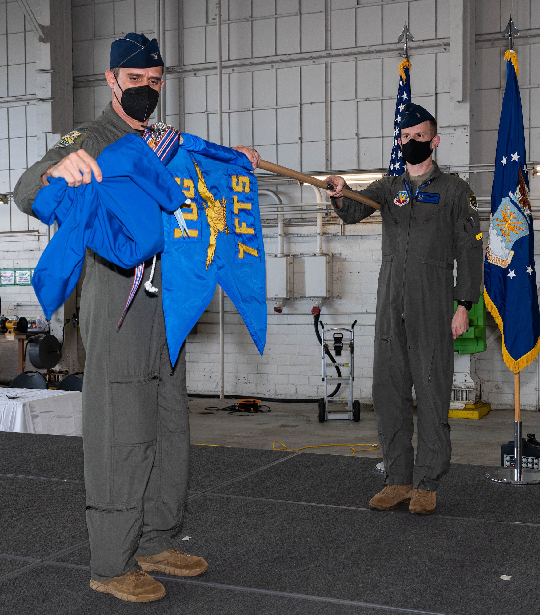 An Airman unveils a new squadron guidon.