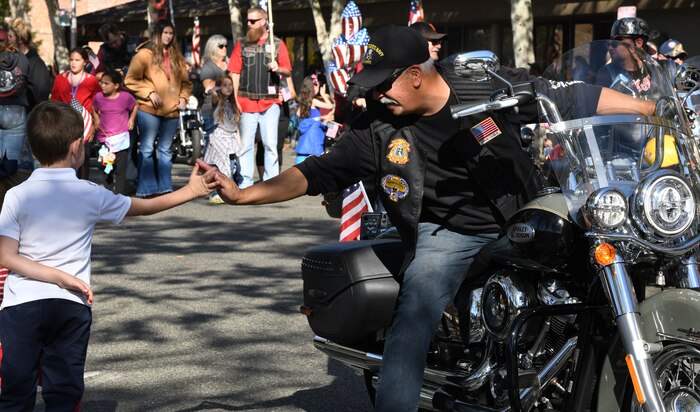 A veteran high-fives a child during a Veterans Day Parade Nov. 11, 2021, in Marysville, California.