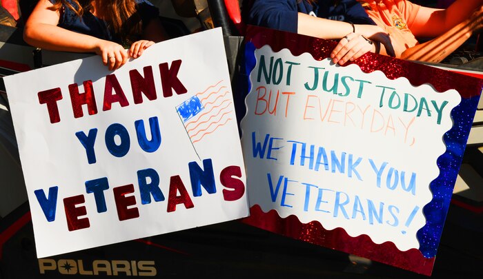 Parade participants hold up signs during a Veterans Day Parade Nov. 11, 2021, in Marysville, California.