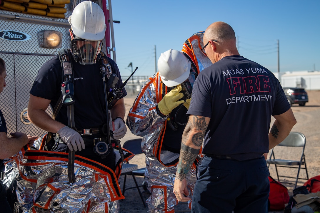 Fire Fighters with Marine Corps Air Station (MCAS) Yuma, Ariz. put on their hazmat suit in order to neutralize a simulated gas leak during exercise Desert Plume, Nov. 2, 2021. Desert Plume is a training that event evaluates MCAS Yuma’s ability to respond to a CBRNE/HAZMAT incident quickly and efficiently. (U.S. Marine Corps photo by Cpl. Gabrielle Sanders)