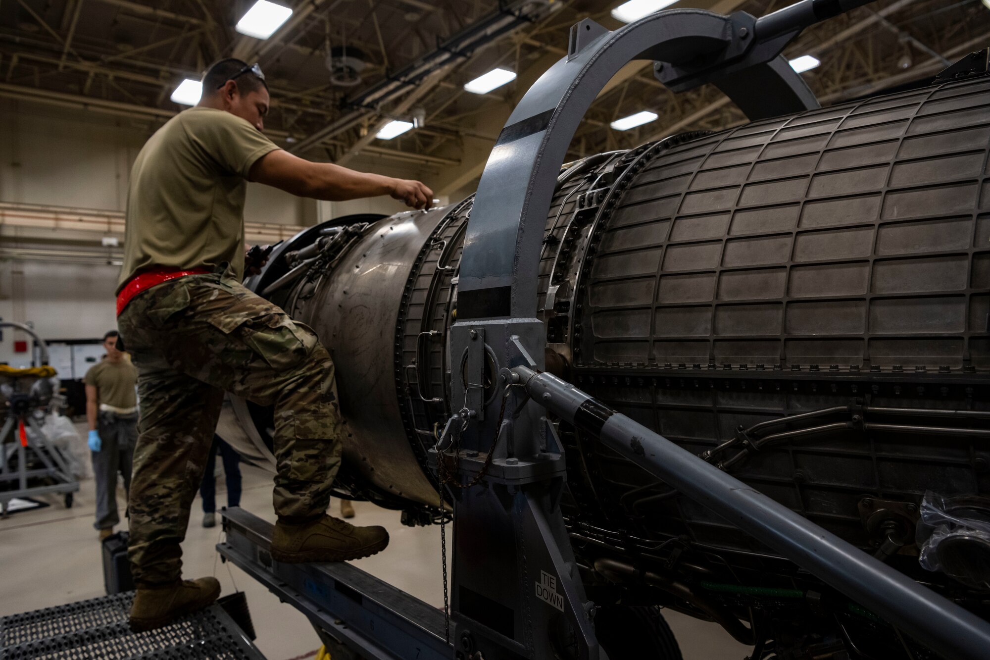 Service member performs maintenance on an F-16 engine.